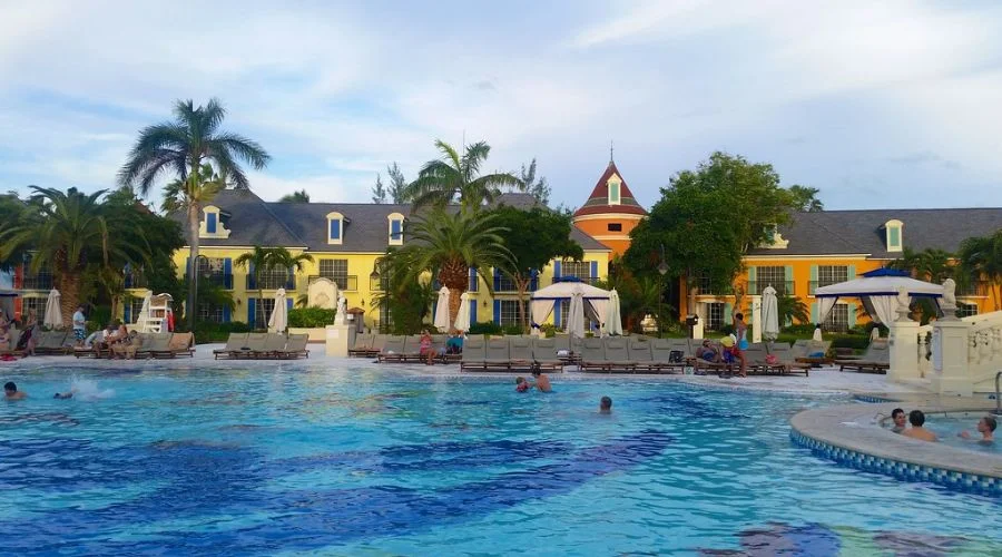 Swimming pool with the colorful lodgings as the backdrop at French Village | Travel Scout